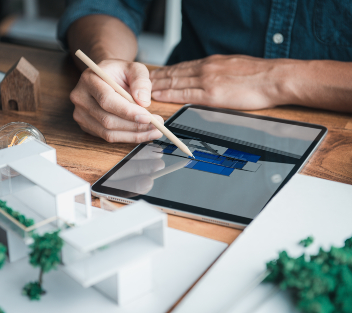 cropped image of man working at architecture desk with a modern tablet