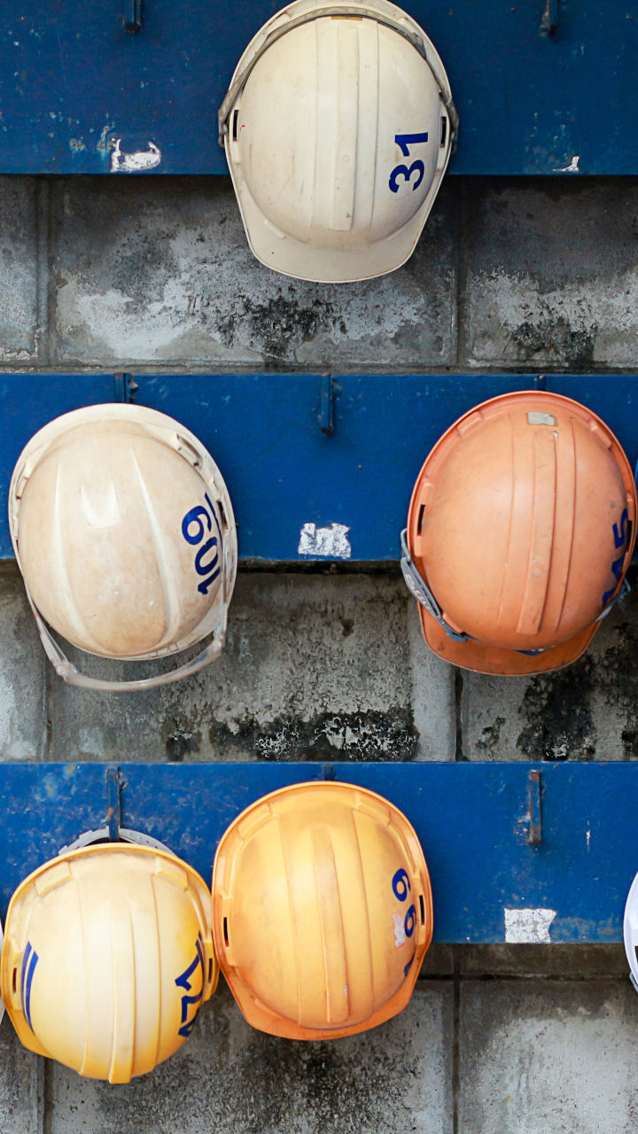 construction hardhats hanging on wall